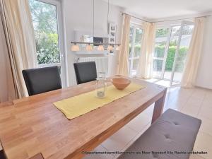 a dining room with a wooden table and chairs at Apartmentvermittlung Mehr als Meer - Objekte 42 & 51 in Niendorf