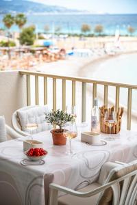 einen Tisch mit Weingläsern und Strandblick in der Unterkunft Le COQ Ligures - Garage - AC - Seafront - WiFi in Roquebrune-Cap-Martin