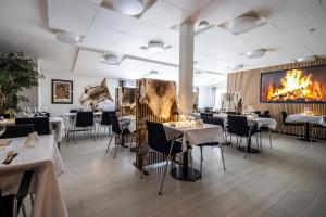 un restaurante con mesas y sillas y una chimenea en HOTEL SØMA Sisimiut en Sisimiut