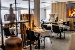 a restaurant with tables and chairs in a room at HOTEL SØMA Sisimiut in Sisimiut