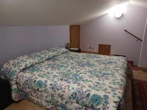 sypialnia z łóżkiem z narzutą kwiatową w obiekcie Locazione turistica vicino Orvieto w mieście Orvieto Scalo