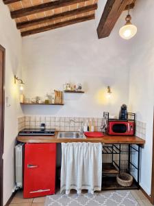 una cucina con bancone e forno a microonde rosso di One bedroom apartement with wifi at Siena a Siena