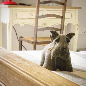 un giocattolo per cani su un letto con una sedia di The Fleur de Lys a Cranborne