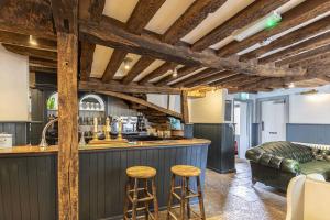eine Küche mit einer Bar und 2 Hockern in der Unterkunft The Fleur de Lys in Cranborne