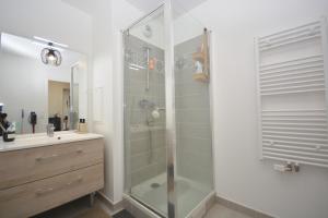 a bathroom with a glass shower and a sink at Appartement Duplex équipé 12 mn saint Lazare et 15mn stade de France in Colombes