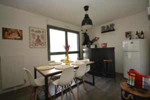 a dining room with a table and white chairs at Appartement Duplex équipé 12 mn saint Lazare et 15mn stade de France in Colombes +26 photos