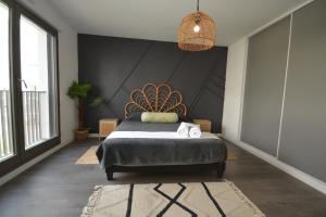 a bedroom with a bed with a large headboard at Appartement Duplex équipé 12 mn saint Lazare et 15mn stade de France in Colombes