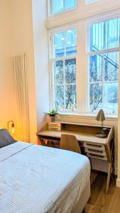 愛丁堡的住宿－Luxury One Bedroom Apartment in the City Centre，一间卧室配有一张桌子、一张床和一个窗户