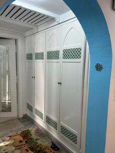 Zimmer mit weißen Schränken und blauer Wand in der Unterkunft Domina coral bay in Sharm El Sheikh