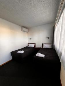 um quarto com duas camas e uma janela em Brooklyne Motel Sanson em Sanson