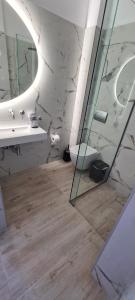 uma casa de banho com um lavatório, um WC e um espelho. em Kiani Akti em Porto Rafti