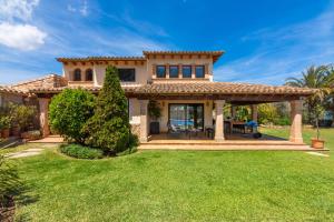 a house with a large backyard with green grass at Moliner PREMIUM VILLA in Pollença