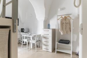 Habitación con tocador blanco y mesa. en Terrazza GiuMaSe by Wonderful Italy, en Ostuni