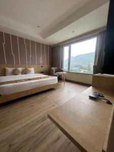 1 dormitorio con cama grande y ventana grande en Sachika Hotels, Guwahati en Guwahati