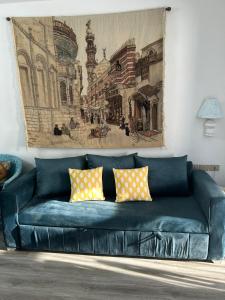 eine blaue Couch in einem Wohnzimmer mit einem Gemälde an der Wand in der Unterkunft Domina coral bay in Sharm El Sheikh