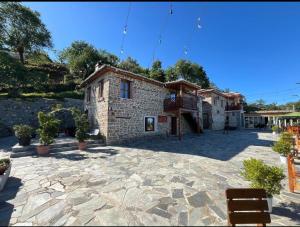 un edificio con un patio de piedra con macetas en Keshtjella Xhabeqos en Tirana