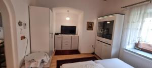 een woonkamer met een televisie en een dressoir met een televisie bij Innenstadtgarten-Wohnung in Wolfsberg