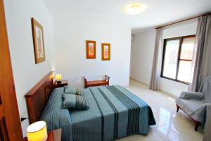 1 dormitorio con 1 cama y 1 silla en Finca Sendra - rustic finca for nature lovers in Benissa, en Benissa