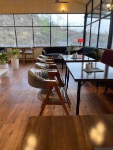 un restaurante con mesas y sillas en una habitación con ventanas en Rootz en Dehradun