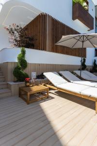 a row of beds with umbrellas on a deck at Levada Charming Houses (Refúgio) - 1 min Metro in Rio Tinto