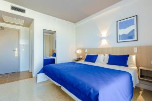 a bedroom with a large blue bed with blue pillows at Cabot Playa Grande - Adults Only in Playa de Palma