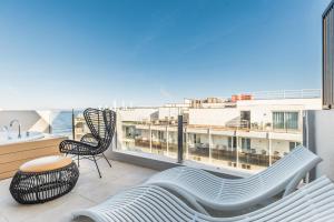 einen Balkon mit einem Sofa, einem Tisch und Stühlen in der Unterkunft Cabot Playa Grande - Adults Only in Playa de Palma