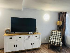 einen Flachbild-TV auf einem weißen Schrank in der Unterkunft The Burgklause Boutique Hotel in Linz am Rhein