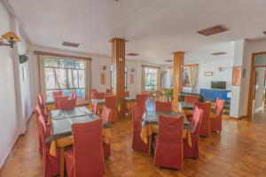 a dining room with tables and red chairs at Hotel Tres Jotas Conil in Conil de la Frontera