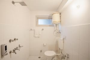 uma casa de banho branca com um WC e um chuveiro em Drifters Inn - The Hidden Tribe em Manali