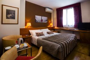 una camera d'albergo con letto, tavolo e sedie di Paradise Hotel & Wellness a Saint Vincent