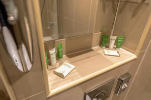 ein Badezimmer mit einem Regal mit vier Zahnbürsten in der Unterkunft Hyde Park International in London