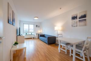 uma sala de estar com uma mesa e um sofá azul em 2 Zimmer mit Balkon, Wohnzimmer mit Arbeitsplatz, zentral, top! em Fürstenwalde