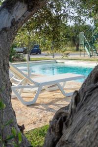 a white picnic table in front of a swimming pool at Trullo Nadia Ostuni in Ostuni