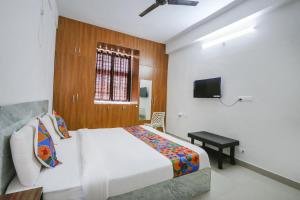 a bedroom with a white bed and a television at FabExpress KP Suites Villas in Turkapally