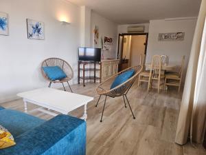 un soggiorno con divano, sedie e tavolo di Apartamento Bressol D a Port de Pollença