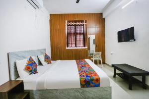 a bedroom with a large bed and a desk in it at FabExpress KP Suites Villas in Turkapally