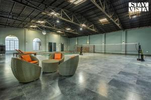 a large room with couches and chairs in it at Arcadian Manor with Indoor Pool Indoor-Outdoor Games at Varanasi by StayVista in Varanasi +15 photos