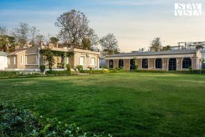 a large yard in front of a house at Arcadian Manor with Indoor Pool Indoor-Outdoor Games at Varanasi by StayVista in Varanasi