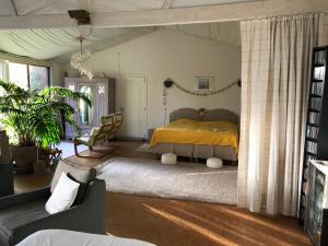 1 dormitorio con 1 cama con colcha amarilla en B&B Koornemoezen en Zedelgem