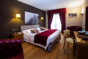 una camera d'albergo con letto e scrivania di Paradise Hotel & Wellness a Saint Vincent