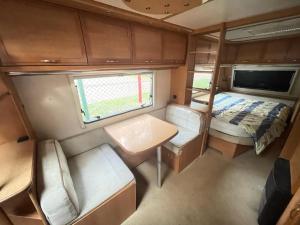 uma vista interior de uma caravana com uma cama e um lavatório em Your Camp Hel em Hel
