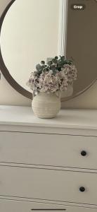 a vase with flowers on a dresser in front of a mirror at Bala Holiday Suites in Bala