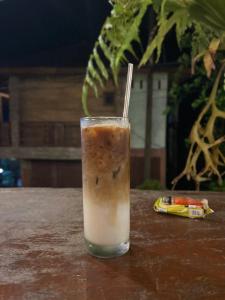 a glass of iced coffee sitting on a table at Garden Grove Guest House & Coffee Bar in Bukit Lawang