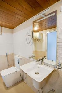 a bathroom with a sink and a toilet and a mirror at Waterfall Villa by Opulence in Talawakele