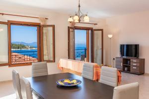una sala da pranzo con tavolo e vista sull'oceano di Mariel House Fiskardo Kefalonia a Fiskardho
