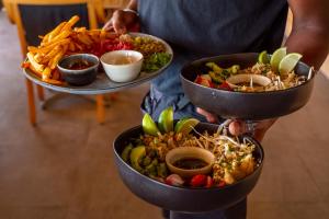 a person holding three trays of different types of food at Sunrise Beach Hotel in Gruissan