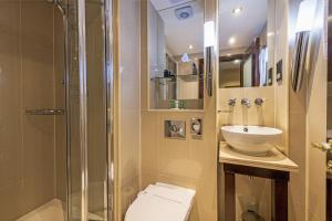 een badkamer met een douche, een toilet en een wastafel bij Hyde Park International in Londen