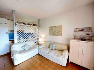 Una sala de estar con un sofá blanco y una ventana. en Splendida spiaggia di Porto Istana Sconti, en Porto Istana