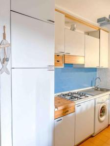 Una cocina con un frigorífico blanco y una lavadora. en Splendida spiaggia di Porto Istana Sconti, en Porto Istana