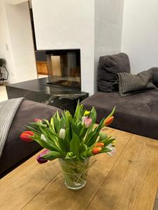 un jarrón de flores sobre una mesa en la sala de estar en Ferienvilla Joachimsberg mit Swimspa und Sauna en Wienerbruck